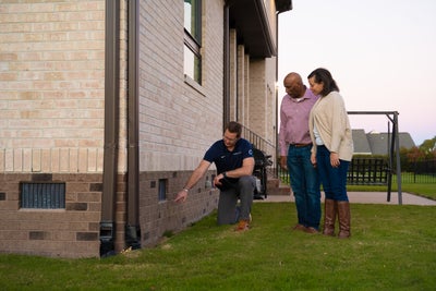 Groundworks inspector showing homeowners a crawl space.