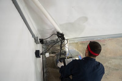 inspector assessing sump pump and other basement waterproofing solutions