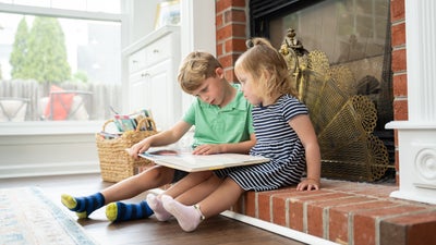children sitting by a fireplace