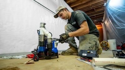 IBA installer setting up a sump pump for installation.