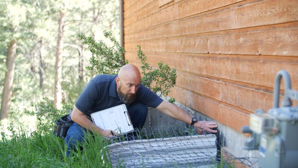 inspector looking at exterior foundation