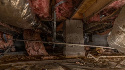 Damaged crawl space with wet insulation.