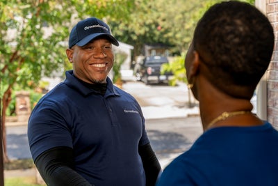 Groundworks inspector shaking hands with homeowners at front door.