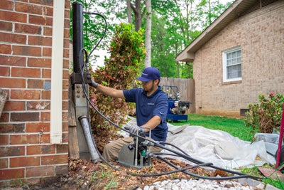 Groundworks crew member installing a pier system.