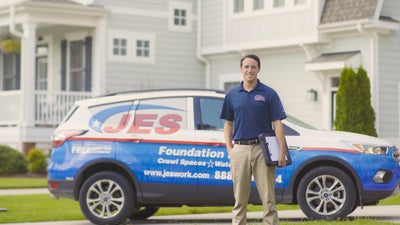 JES inspector standing in front of work truck and house