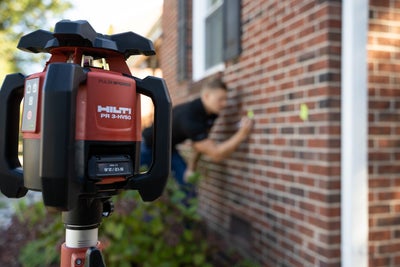 inspector using a laser level and benchmarking a foundation wall