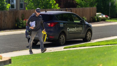 Groundworks worker walking to a customers home from his company vehicle.