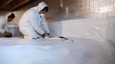 AquaGuard crawl space encapsulation system being installed.