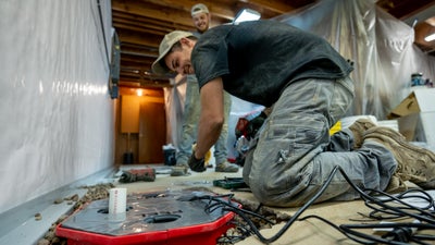 A worker fixing a flooded basement.
