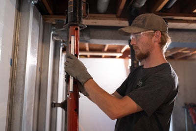 Professional Groundworks tech prepping the walls before positioning the metal beam