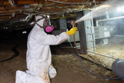 applying mold biocide spray in crawl space