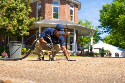 Groundworks tech working on pool deck on a summer day