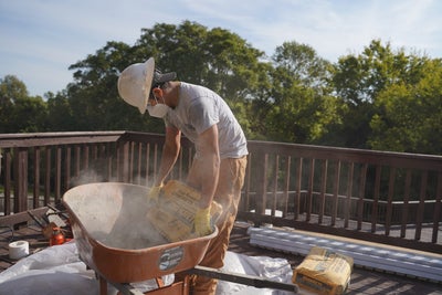 crew member concrete bags wheelbarrow deck
