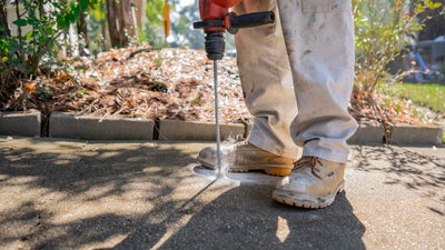 crew member repairing concrete crack with polyrenewal concrete lifting tool