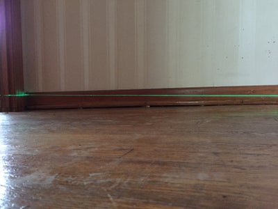 Sagging floor with laser level showing uneveness.