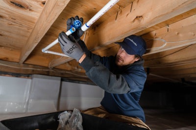 worker installing crawl space drainage