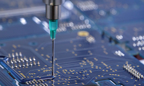 Un matériau photopolymérisable Dymax est déposé sur une carte de circuit imprimé.