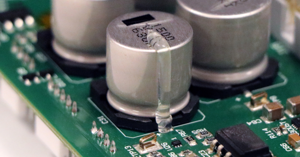 Close up of printed circuit board component staked with Dymax adhesive.