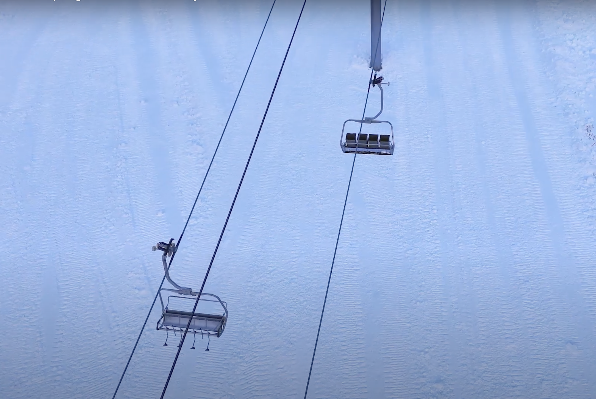 overhead view of chairlift on snowy slope