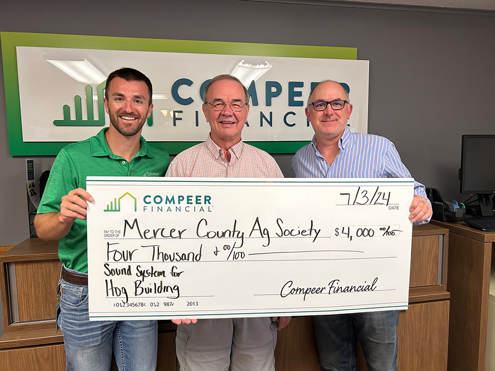 Three men holding a large check from Compeer Financial to Mercer County Ag Society for $4,000 for a sound system for the hog building.