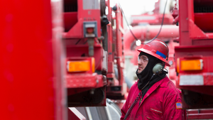 Halliburton employee in red coveralls on a frac site.