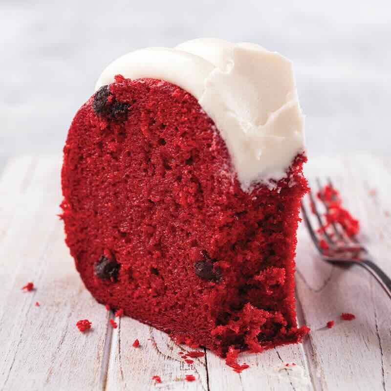Red Velvet slice, showing chocolate chips baked into the cake and signature frosting on top - Shop Bundt Cakes