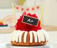 Bundt cake with red bow, adorned with a school-themed banner and a mini chalkboard.