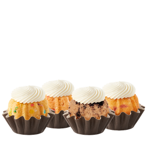 Four Bundtinis sitting in a row. Confetti, Strawberries & Cream, Oreo Cookies & Cream, and Lemon Raspberry.