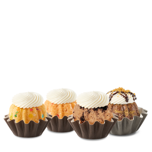 Four Bundtinis sitting in a row. Confetti, Strawberries & Cream, Oreo Cookies & Cream, and S'mores Made With HERSHEY'S.
