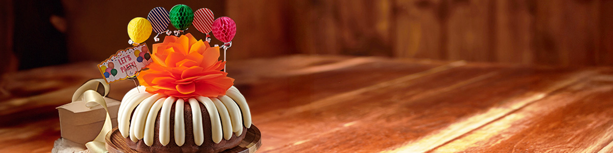 Lets Party Birthday Bundt Cake - with a orange bow and decorative cake paper balloon banner