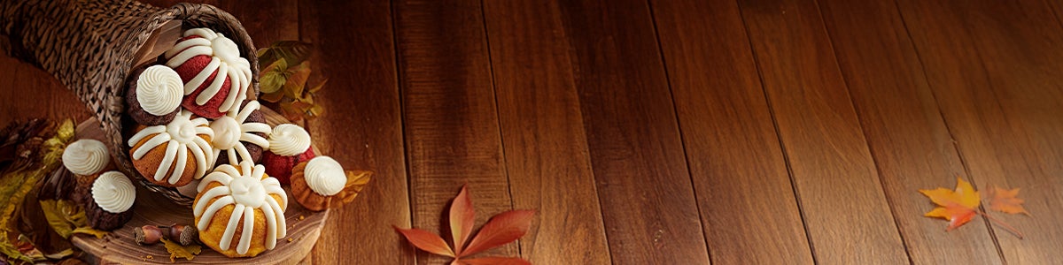 A bundt cake and assorted bundtlets and bundtinis on a wooden table.