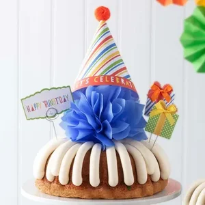 Happy 'Bundt'day Bundt Cake with a party hat and two miniature gifts -- Shop Now.