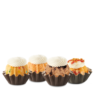 Four Bundtinis sitting in a row. Confetti, Strawberries & Cream, Oreo Cookies & Cream, and Strawberry Cheesecake Swirl.