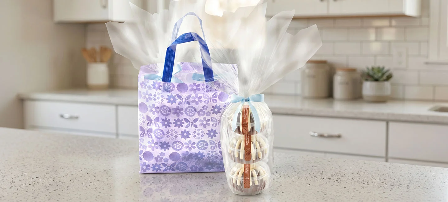 A bundt cake with a blue bow on top, a double bundtlet tower with a blue ribbon, and four bundtinis with school-themed toppers.