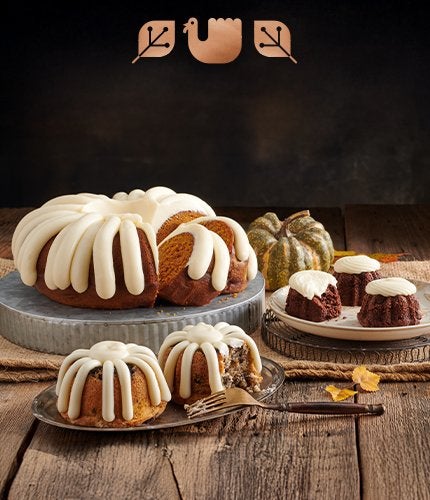 A bundt cake and assorted bundtlets and bundtinis on a wooden table.