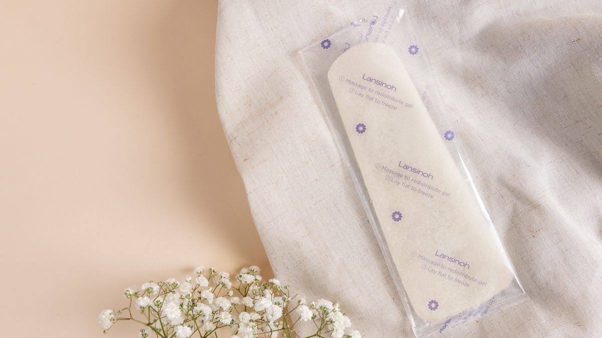 A sealed Lansinoh gel pad for breastfeeding on a cloth with flowers.