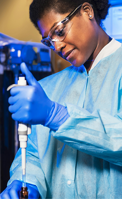 A female scientist working with a pipette in a lab. 