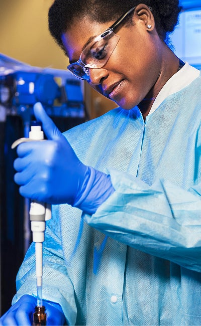 A female scientist working with a pipette in a lab.&nbsp;