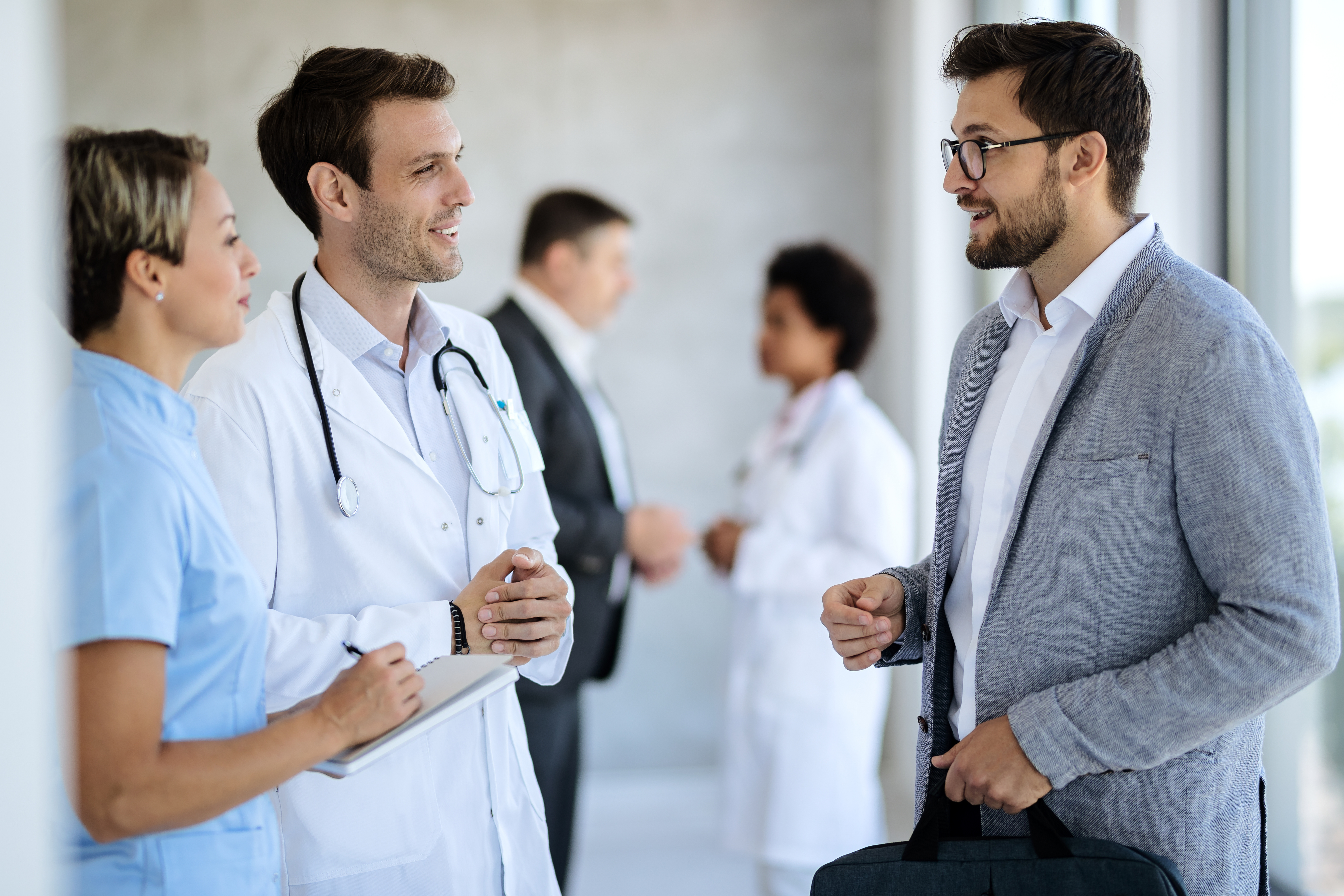 A group of doctors and nurses are talking to each other in a hospital hallway