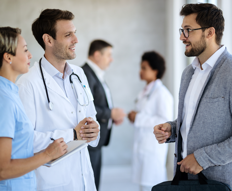 A group of doctors and nurses are talking to each other in a hospital hallway