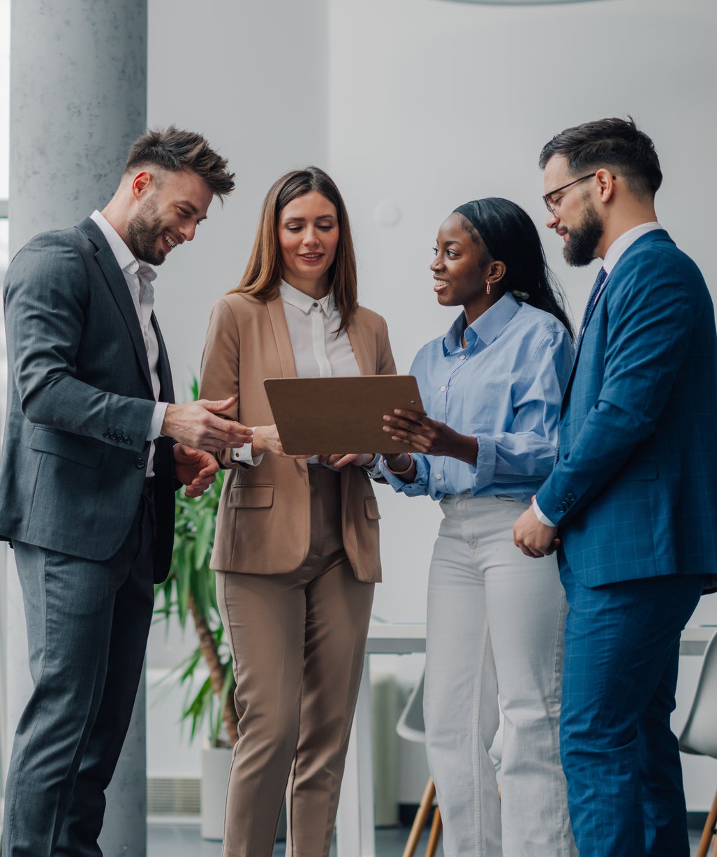 Four professionals reviewing a document in an office