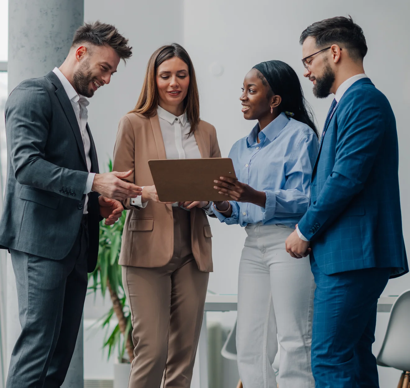 Four professionals reviewing a document in an office