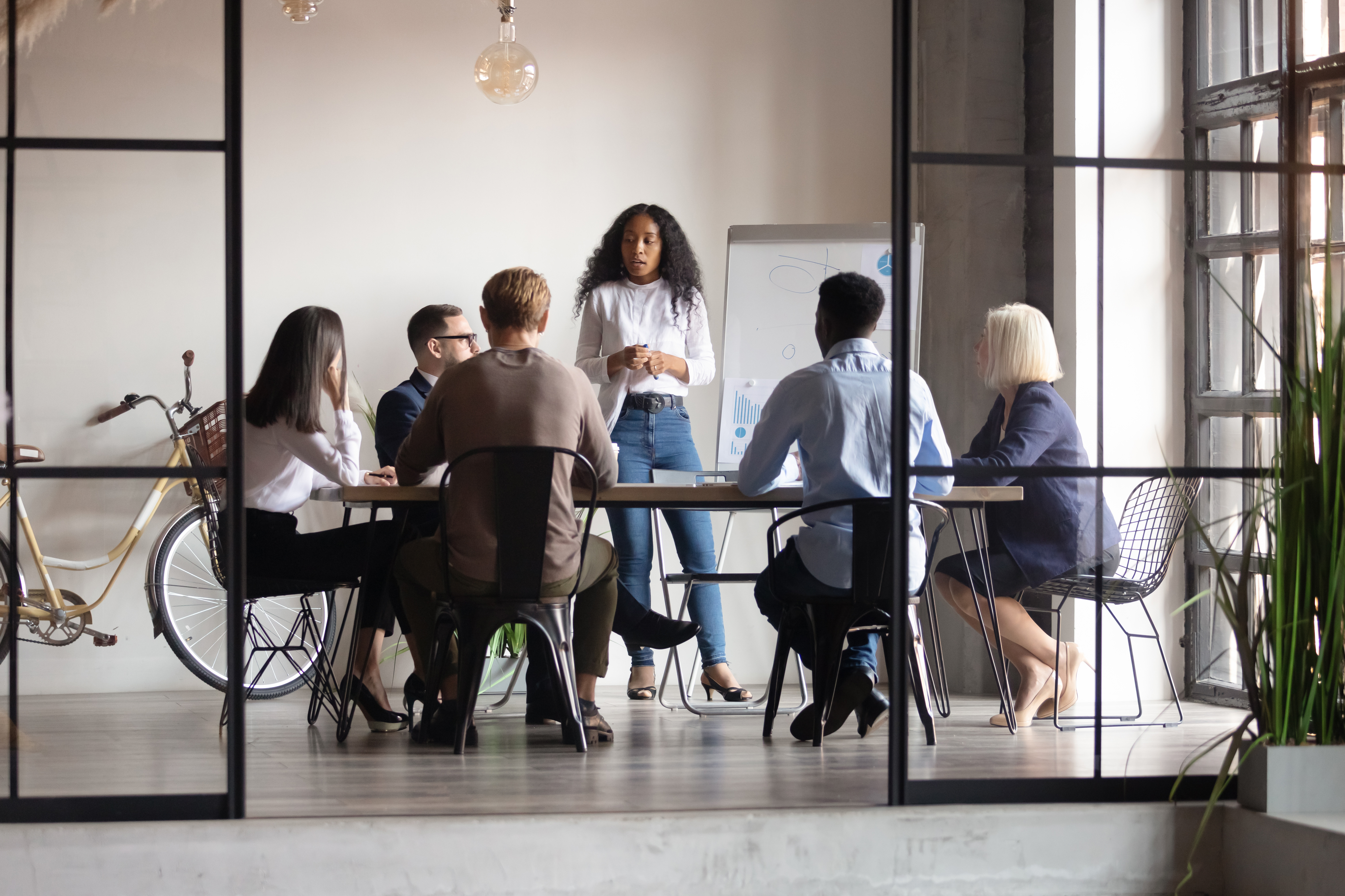A group of people are sitting around a table in a conference room