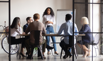 A group of people are sitting around a table in a conference room