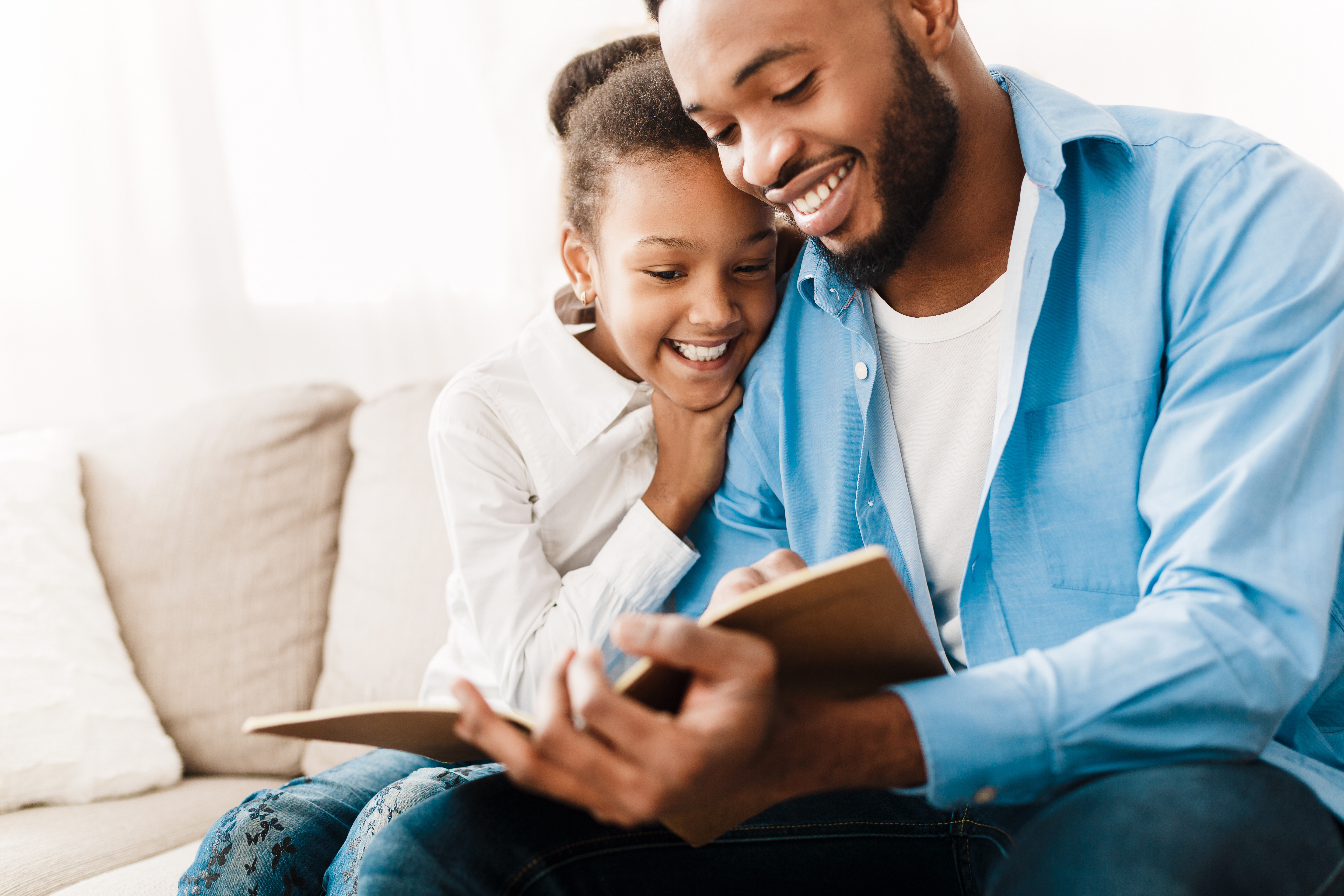 Father and daughter happily reading a book