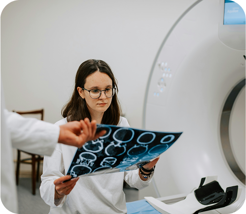 A female doctor viewing scans in an MRI room.