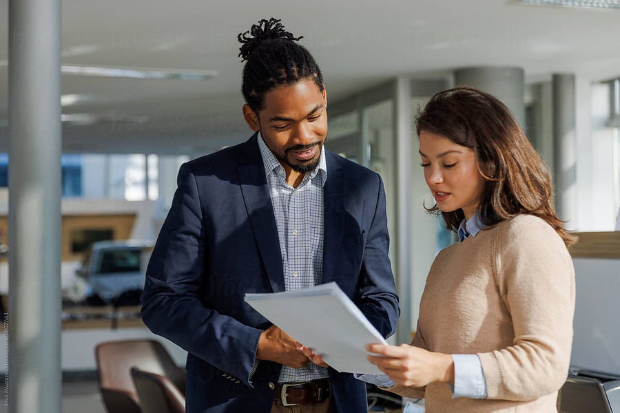 Two people reviewing documents in a modern office.