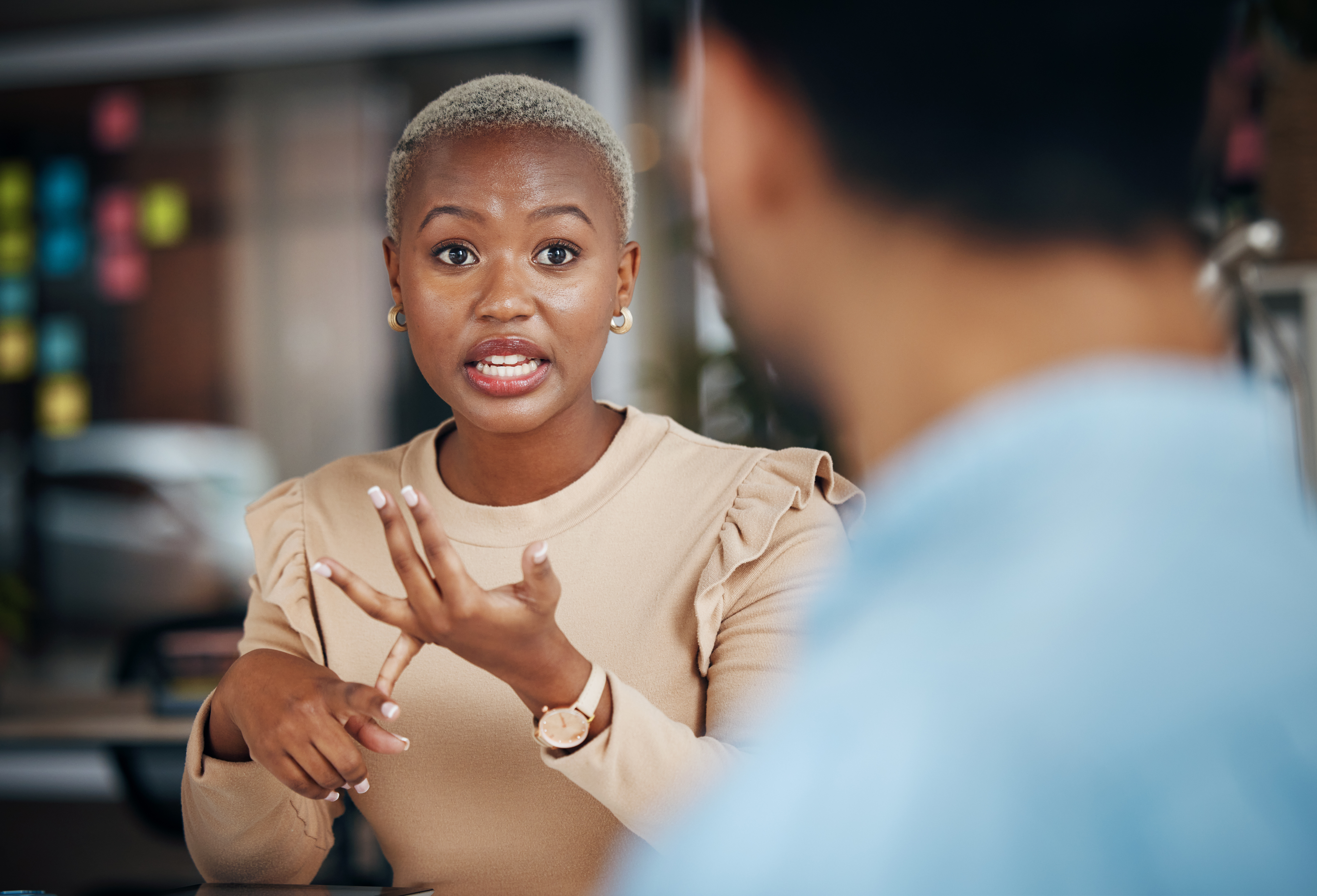 A woman is sitting at a table talking to a man