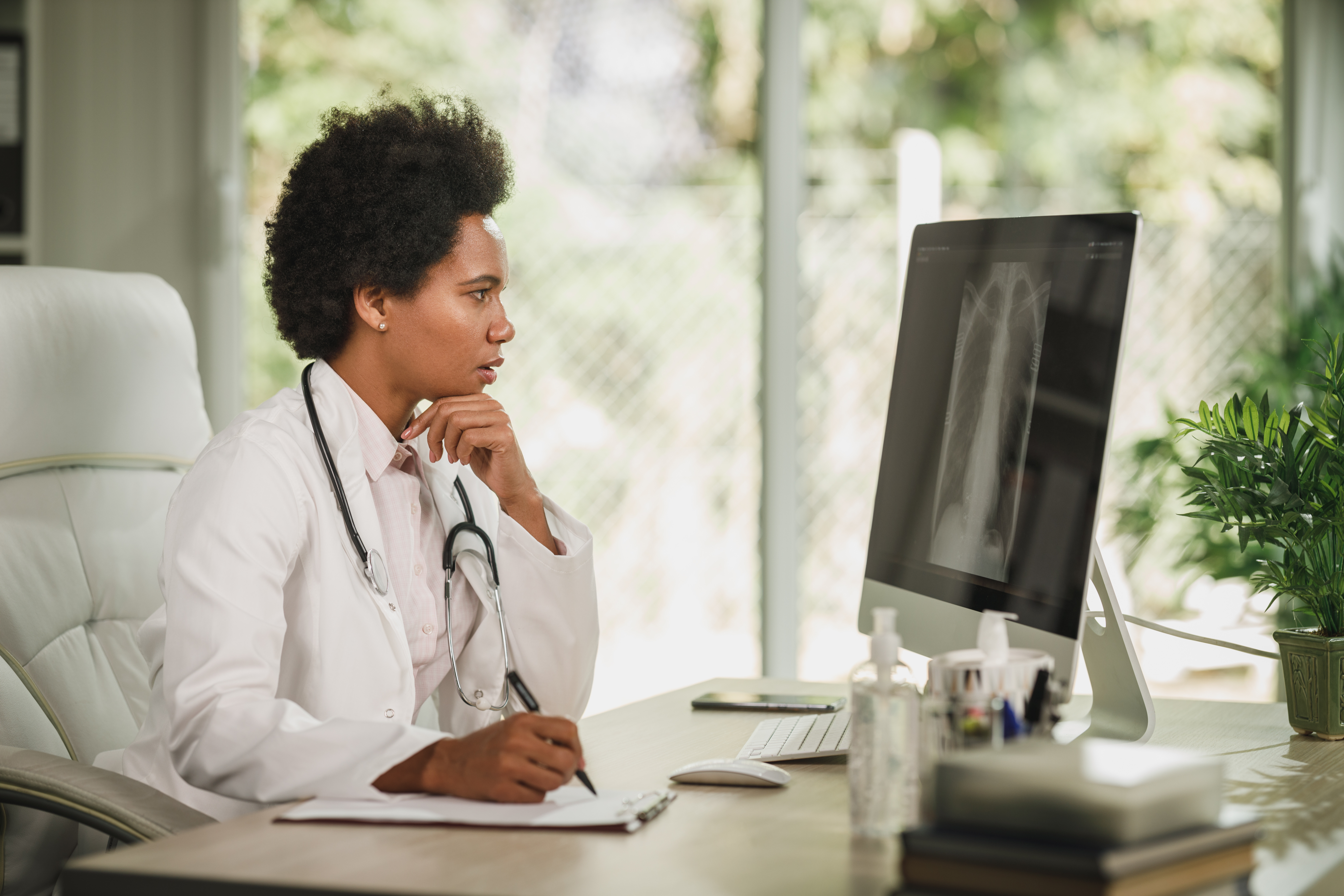 Doctor examining lung x-ray results on computer screen.