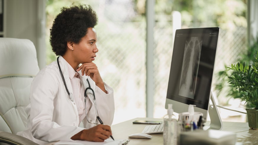 Doctor examining lung x-ray results on computer screen.